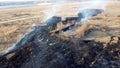 Aerial Drone View burning dry grass. Open flames of fire and smoke. Yellow Dry