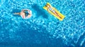 Aerial drone view of children in swimming pool from above, happy kids swim on inflatable ring donuts, girls have fun in water