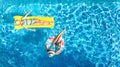 Aerial drone view of children in swimming pool from above, happy kids swim on inflatable ring donuts, girls have fun in water