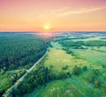 Aerial view of a country road between forest and meadow Royalty Free Stock Photo