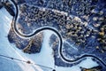 Aerial drone view of a curved winding road through the forest up in the mountains in the winter with snow covered trees Royalty Free Stock Photo