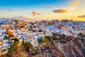 Aerial drone view of famous Oia village with white houses and blue dome churches during sunrise on Santorini island, Aegean sea, Royalty Free Stock Photo