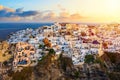 Aerial drone view of famous Oia village with white houses and blue dome churches during sunset on Santorini island, Aegean sea, Royalty Free Stock Photo