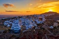 Aerial drone view of famous Oia village with white houses and blue dome churches during sunset on Santorini island, Aegean sea, Royalty Free Stock Photo