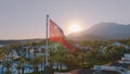 Aerial drone view of the flag flying on the roof. Sunset. Swimming pool, palm trees and mountains in the background Royalty Free Stock Photo