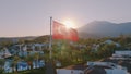 Aerial drone view of the flag flying on the roof. Sunset. Swimming pool, palm trees and mountains in the background Royalty Free Stock Photo