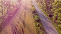 Aerial drone view flight over highway, wheat field and green trees at sunset Royalty Free Stock Photo