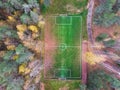 Aerial drone view of football soccer pitch field, green grass fall autumn vibrant pitch playground with fallen multicolored leaves