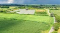 Aerial drone view of green fields and farm houses near canal, typical Dutch landscape, Holland, Netherlands Royalty Free Stock Photo