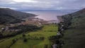 Aerial drone view of green fields with a seascape in Scotland at sunset Royalty Free Stock Photo