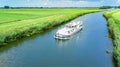 Aerial drone view of houseboat in canal and country landscape of Holland from above, family travel by barge boat in Netherlands