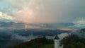 Aerial drone view of Jamnik, Slovenia. Rainbow, Alps and Church of St. Primoz