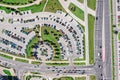 Aerial drone view of large parking lot and car traffic on city street