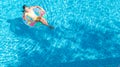 Aerial drone view of little girl in swimming pool from above, kid swims on inflatable ring donut , child has fun in blue water Royalty Free Stock Photo