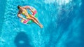 Aerial drone view of little girl in swimming pool from above, kid swims on inflatable ring donut , child has fun in blue water Royalty Free Stock Photo