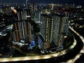 Aerial drone view of modern apartment building in Jakarta central business district at night with Jakarta cityscape. JAKARTA, Royalty Free Stock Photo