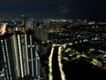 Aerial drone view of modern apartment building in Jakarta central business district at night with Jakarta cityscape. JAKARTA, Royalty Free Stock Photo