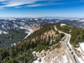 Aerial drone view, narrow asphalt road leading to the top of the mountain at springtime