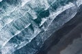 Aerial drone view of ocean waves washing black sand beach, Iceland