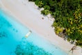 Aerial drone view of paradise beach with coconut trees and lonely tourist boat in turquoise shallow lagoon water Royalty Free Stock Photo