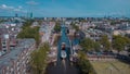 Aerial drone view of a ship passing elevating road bridge in amsterdam canal. Ship under open bridge over the canal