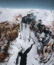 Aerial drone view of Skogafoss waterfall in winter with blue sky and colourful orange grass. Royalty Free Stock Photo