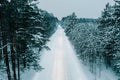 Aerial drone view of snowy winter road in forest Royalty Free Stock Photo