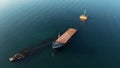 Aerial drone view of sunken cargo ship or tug boat near seaside. Shipwreck vessel with nose of ship above sea water