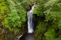 Aerial drone view of a tall waterfall in a narrow canyon surrounded by trees Sgwd Einion Gam, Wales, UK