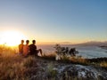 Aerial drone view of three young male hikers enjoying the sunset view on the summit of Diamond Head Crater