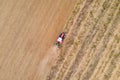 Aerial drone view of a tractor plowing in a field