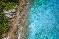 Aerial drone view of tropical coastline, crystal clear turquoise ocean water, bizarre granite rocks and coconut palm