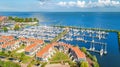 Aerial drone view of typical modern Dutch houses and marina in harbor from above, architecture of port of Volendam town