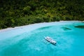 Aerial drone view of a vast scenic tropical sandy beach with lush rainforest and banca boats. Getaway dreamy place raw