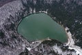 Aerial drone view of a volcanic crater lake at winter. Flying above Sfanta Ana lake, Szent Anna lake, Szeklerland, Transylvania,