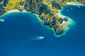 Aerial drone view of white boat in open sea, tropical island and beach of Miniloc Island. El Nido, Palawan island Royalty Free Stock Photo