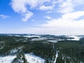 Aerial drone view of a winter landscape. Snow covered forest and lakes from the top. Sunrise in nature from a birds eye view. Royalty Free Stock Photo