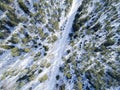 Aerial drone view of a winter road landscape. Snow covered forest and road from the top. Sunrise in nature from a birds eye view Royalty Free Stock Photo