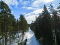 Aerial drone view of a winter road landscape. Snow covered forest and road from the top. Sunrise in nature from a birds eye view Royalty Free Stock Photo