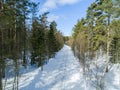 Aerial drone view of a winter road landscape. Snow covered forest and road from the top. Sunrise in nature from a birds eye view Royalty Free Stock Photo