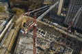 Aerial drone view on working tower cranes and constraction site with construction machines, vehicles and workers at work