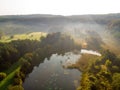 Aerial early morning view of trees and river. Beautiful foggy forest scene in autumn with orange and yellow foliage Royalty Free Stock Photo