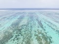 AERIAL: Female snorkeler dives around turquoise ocean and explores coral reef Royalty Free Stock Photo