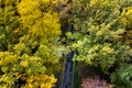 Aerial flight above winding road in autumn forest