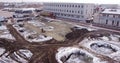 Aerial flight over the development of a site of new structures, where heavy machinery and construction workers work with Royalty Free Stock Photo