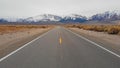 AERIAL: Flying above the empty freeway with a perfect view of the snowy Rockies.