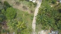 AERIAL: Flying above a female tourist riding her scooter through remote village. Royalty Free Stock Photo