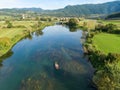 AERIAL: Flying above a group of friends cruising in a canoe along a calm river. Royalty Free Stock Photo