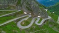 AERIAL: Flying above a hairpin road meandering up the beautiful Swiss mountains