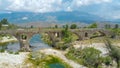 AERIAL: Flying above tourist girl walking along the ancient ottoman bridge.